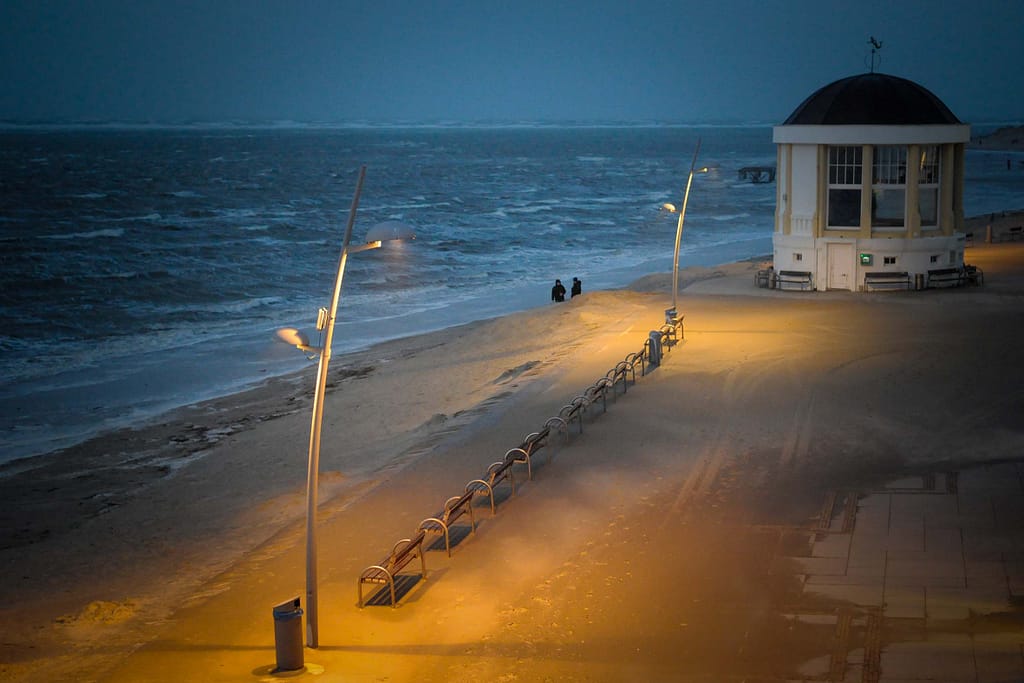 Die Promenade liegt im warmen Licht, ein starker Kontrast zu den schwarzen Wolken auf See. Foto: Oliver Abraham