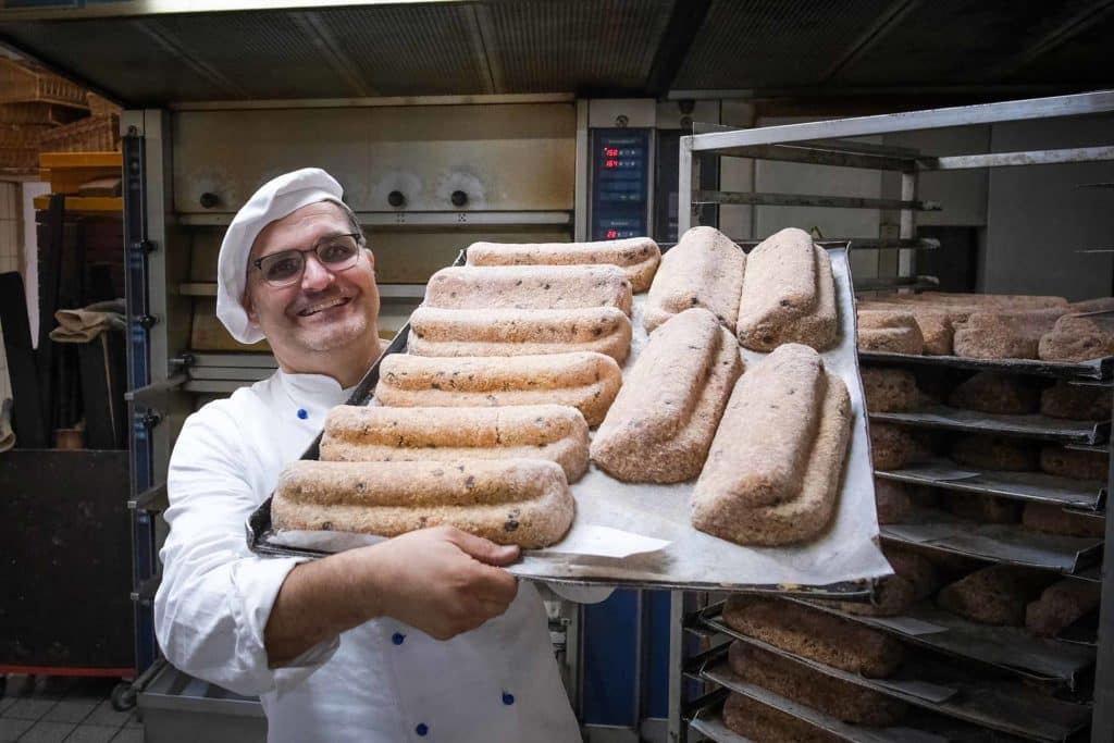 Christstollen aus dem Bergwerk Ramsbeck: Ein Sauerländer Genuss-Geheimnis 7 Jörg Liese hält in seiner Backstube in Bestwig-Ostwig ein Blech mit Christstollen. Foto: Mario Vedder